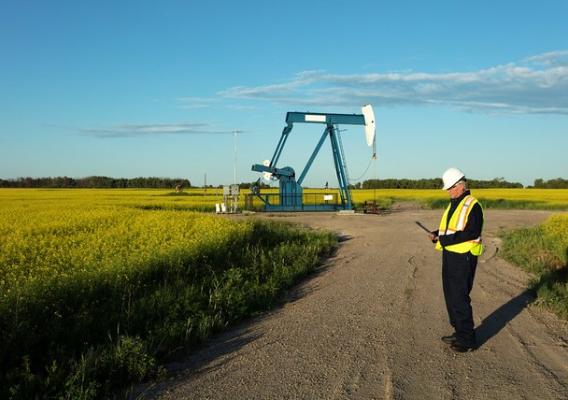 A man in front of an oil pump