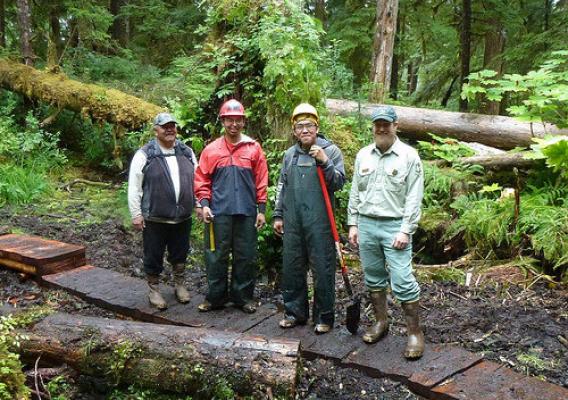 A new foot bridge near the tribal village of Angoon on Admiralty Island National Monument is part of a Tongass National Forest and Youth Conservation Corps partnership. From left, Tribal Liaison Donald Frank, Angoon Trail Crew Leader Aaron McCluskey, Youth Conservation Corps member Roger Williams, also an Angoon tribal member, and Admiralty Island National Monument Ranger Chad VanOrmer pause work to celebrate the bridge’s construction and the agency’s successful Corps partnership with the Angoon Tribe. (U.S