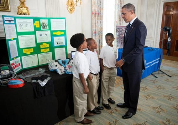 President Barack Obama talks with Evan Jackson, 10, Alec Jackson, 8, and Caleb Robinson, 8, from McDonough, Ga., while looking at exhibits at the White House Science Fair in the State Dining Room, April 22, 2013. The sports-loving grade-schoolers created a new product concept to keep athletes cool and helps players maintain safe body temperatures on the field. (Official White House Photo by Chuck Kennedy)