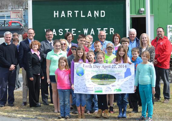 USDA Rural Development State Director Virginia Manuel (back row second from right) announced Earth Day funds in the amount of $29.7 million to assist rural wastewater systems in Maine, including the Town of Hartland. Children from the Hartland community took time away from their school vacation to sign the official USDA Earth Day Banner.