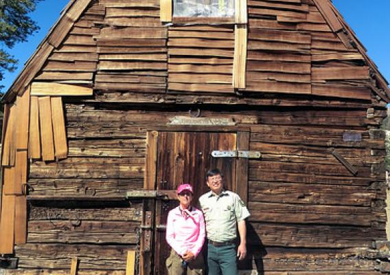 Current range permittee Lynn Sanguinetti and Fred Wong, U.S. Forest Service district ranger, stand in front of a cabin
