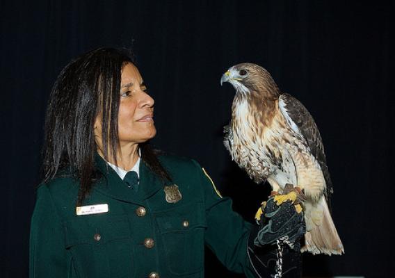Jo Santiago, a U.S. Forest Service Wildlife Biologist with a red-tailed hawk