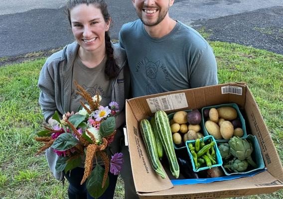 Eryn Leavens and Oliver Gawlick with boxes of fresh produce provided free to their neighbors and community